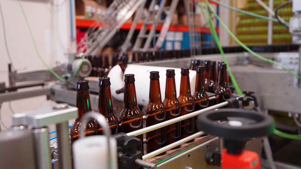 Botellas de cerveza en una cinta transportadora en una fábrica