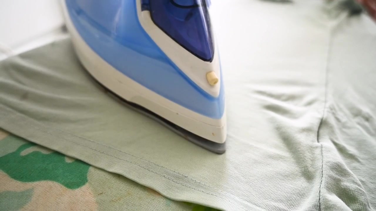 Woman ironing a white shirt at home