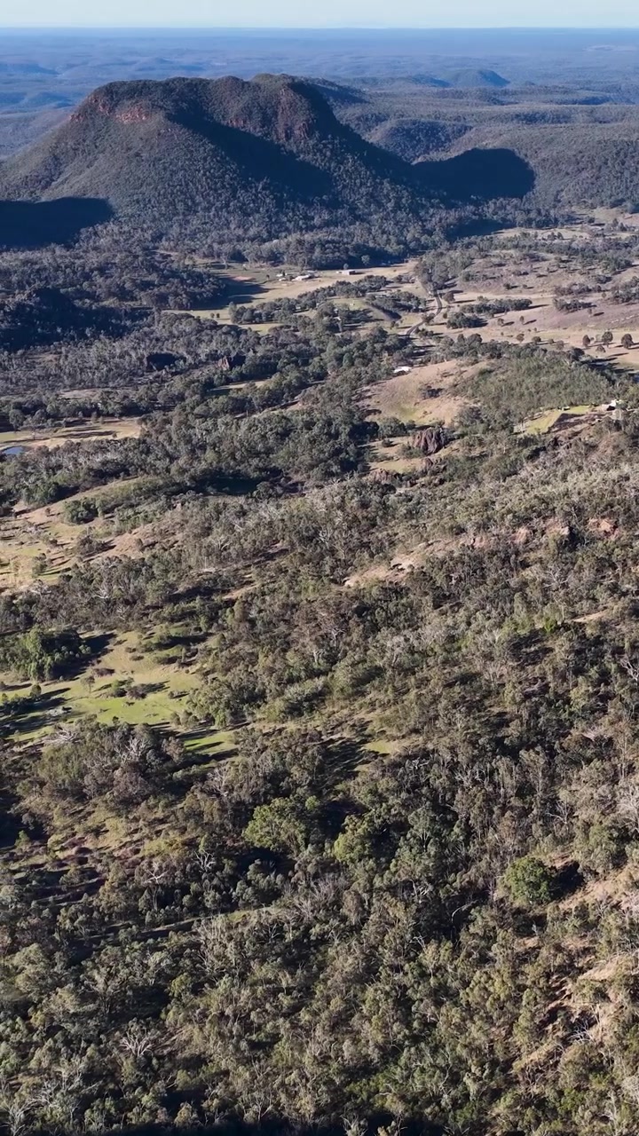 Ripresa con Drone che Panoramica su Aspre Cime Vulcaniche e Fitta Foresta di Eucalipti nel Nuovo Galles del Sud