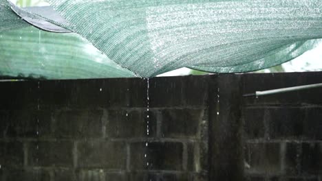 rain dripping through a mesh roof cover, slow motion