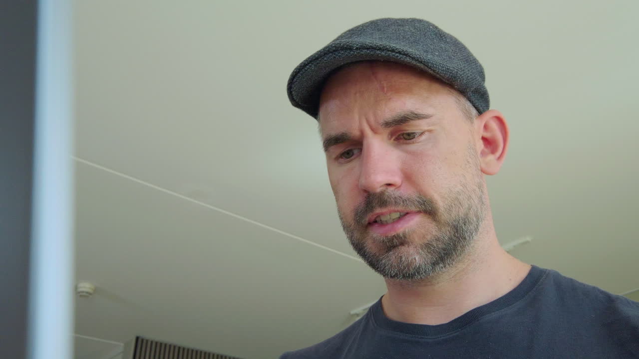 vista de cerca de un hombre serio trabajando en su computadora portátil en casa