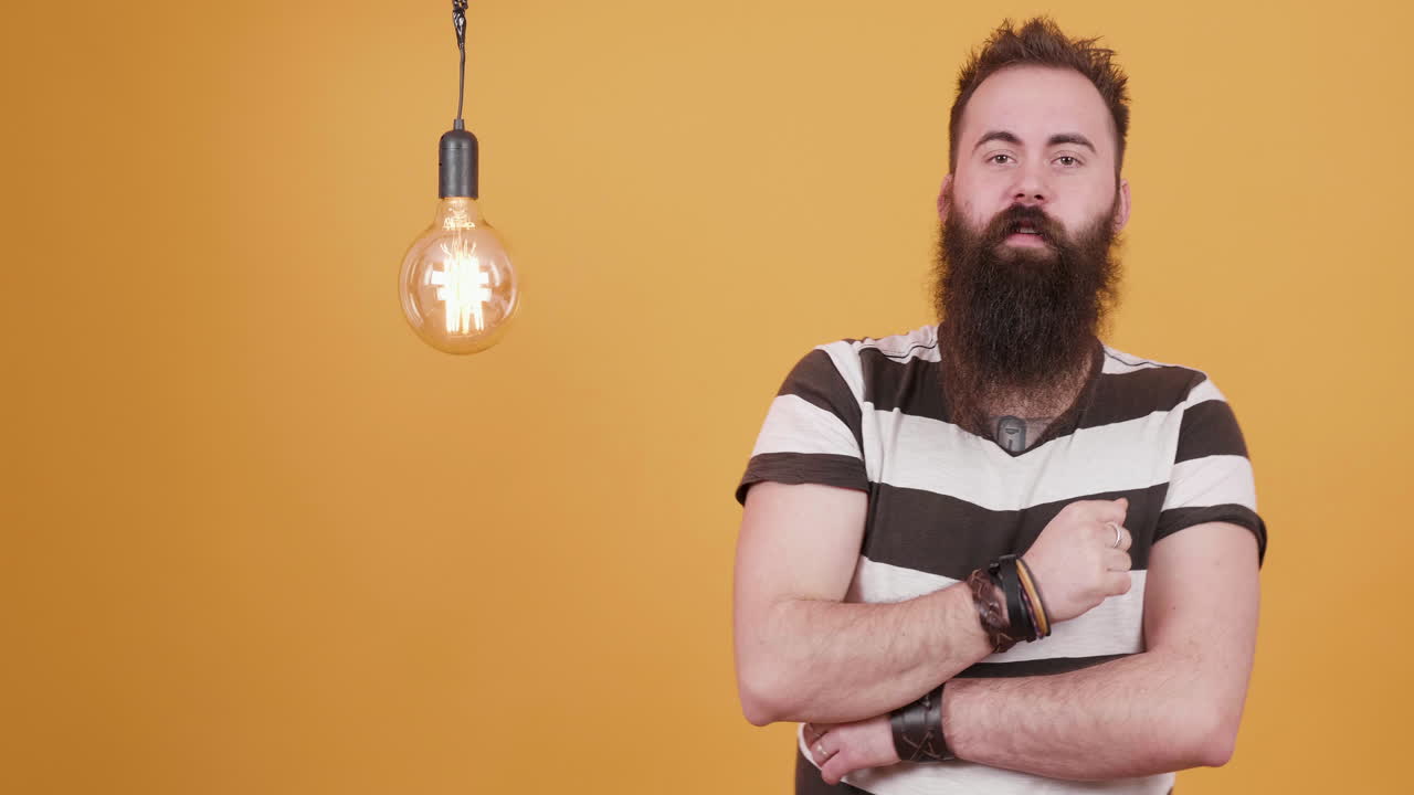 Man with beard thinking near a light bulb