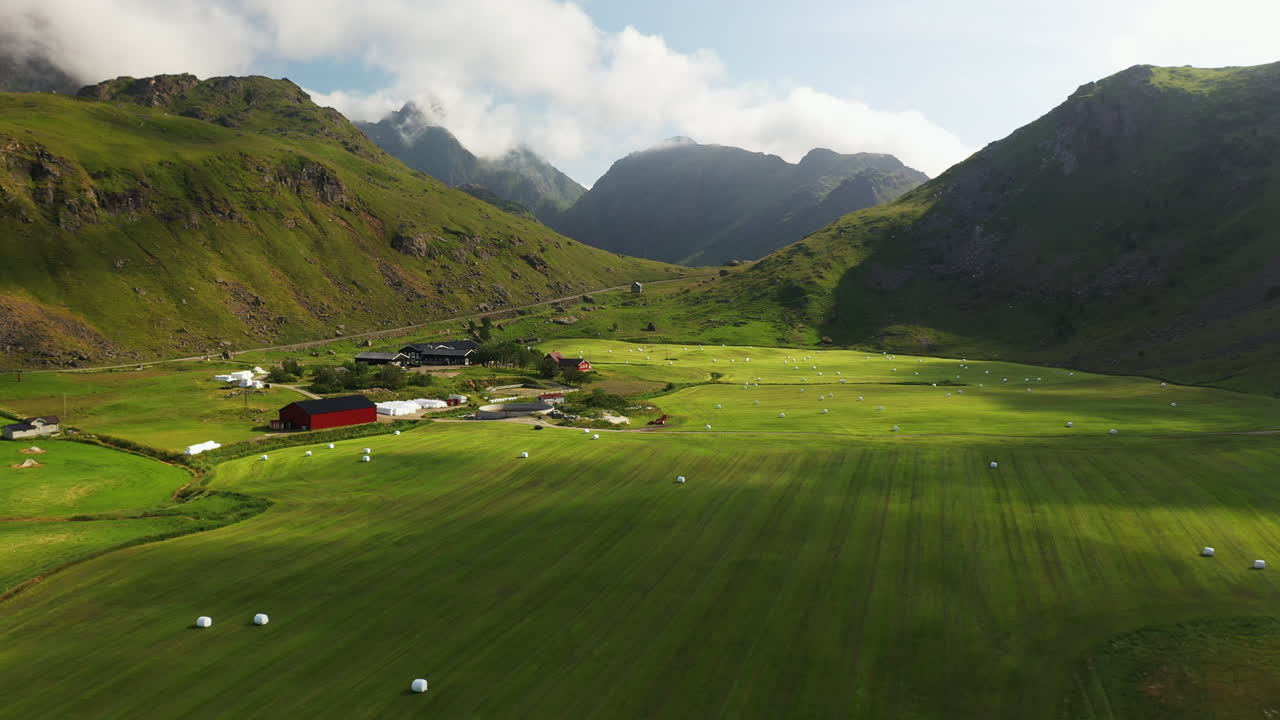imágenes aéreas de la playa de vik y hauklandstranda noruega, avión no tripulado de tierras de cultivo con bailes de heno enrollados en el valle de la montaña