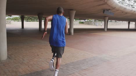 rear view man with prosthetic leg running