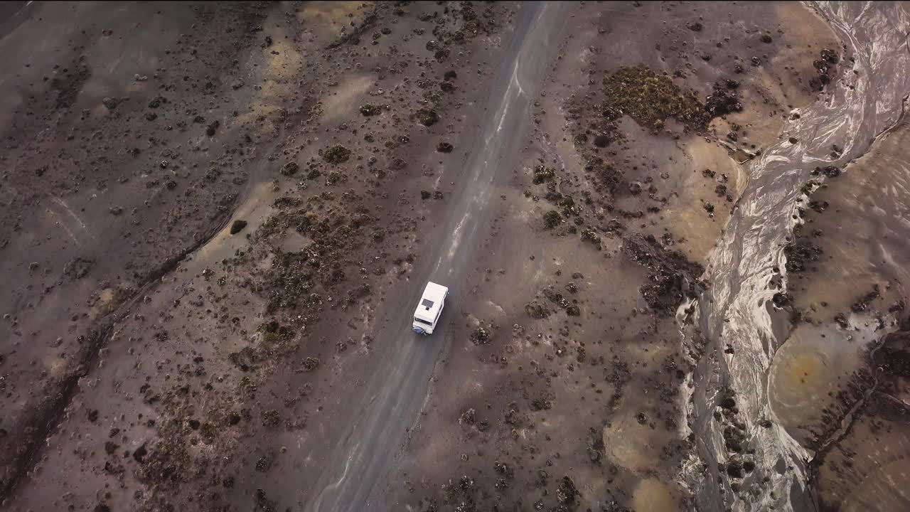 una vieja autocaravana conduce por el desierto en la carretera de acceso de tukino, parque nacional de tongariro - desierto de rangipo