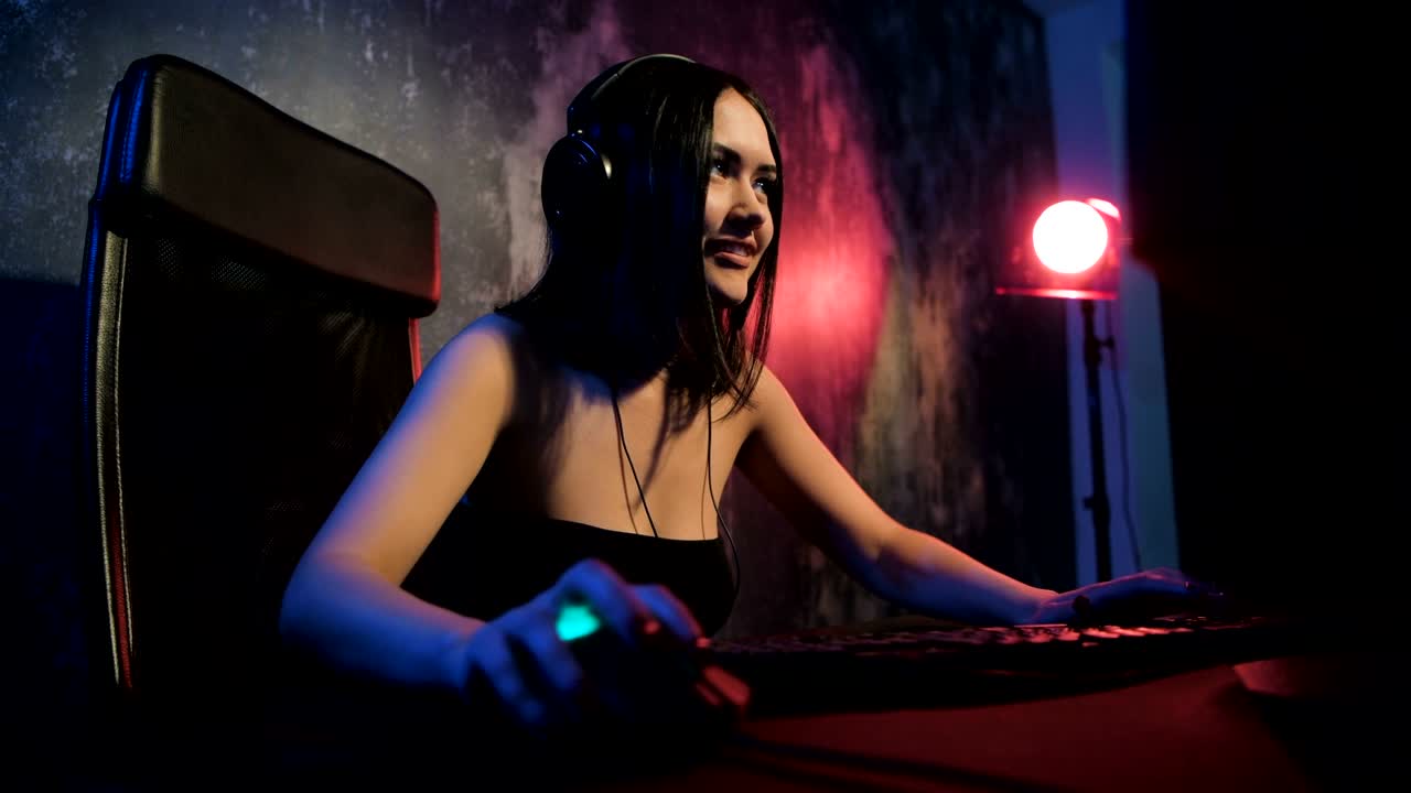 Jogadora profissional joga um MMORPG ou jogo de estratégia no computador dela. Ela está participando de um torneio de eSports online, joga em casa ou em um cybercafé. Ela usa um headset gamer.