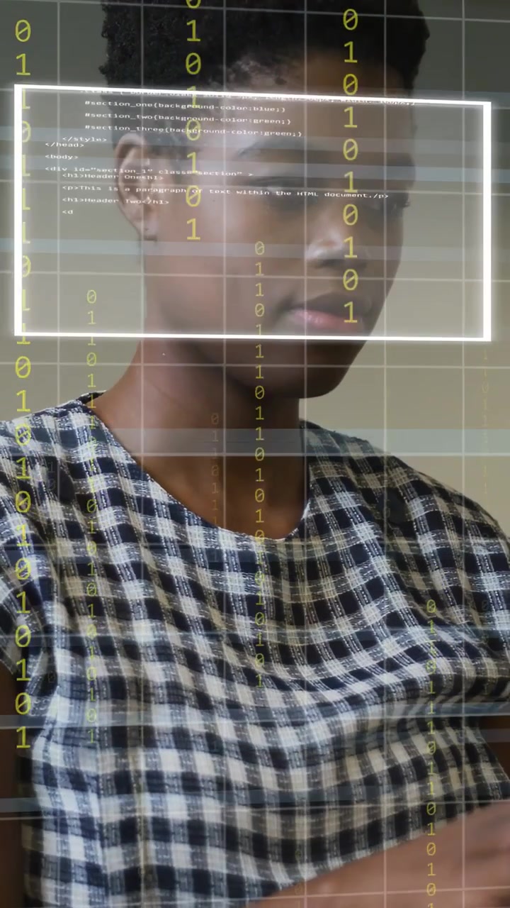 Vertical video: Woman typing at laptop, laptop sensing focus and showing binary UI for tech demo