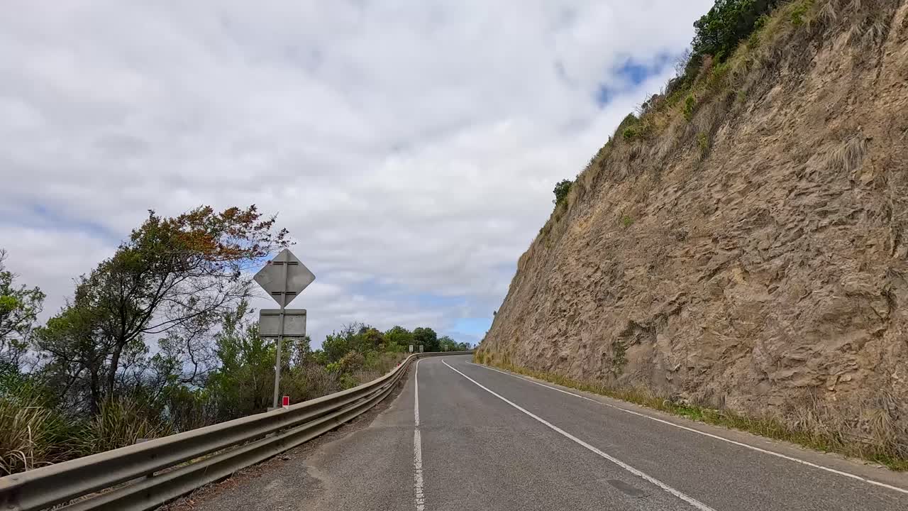 A 14-second video captures a scenic drive along the winding Great Ocean Road in Australia, showcasing coastal views and rugged cliffs