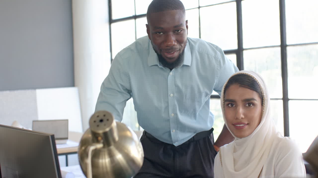 Business colleagues collaborating on project, using computer in modern office