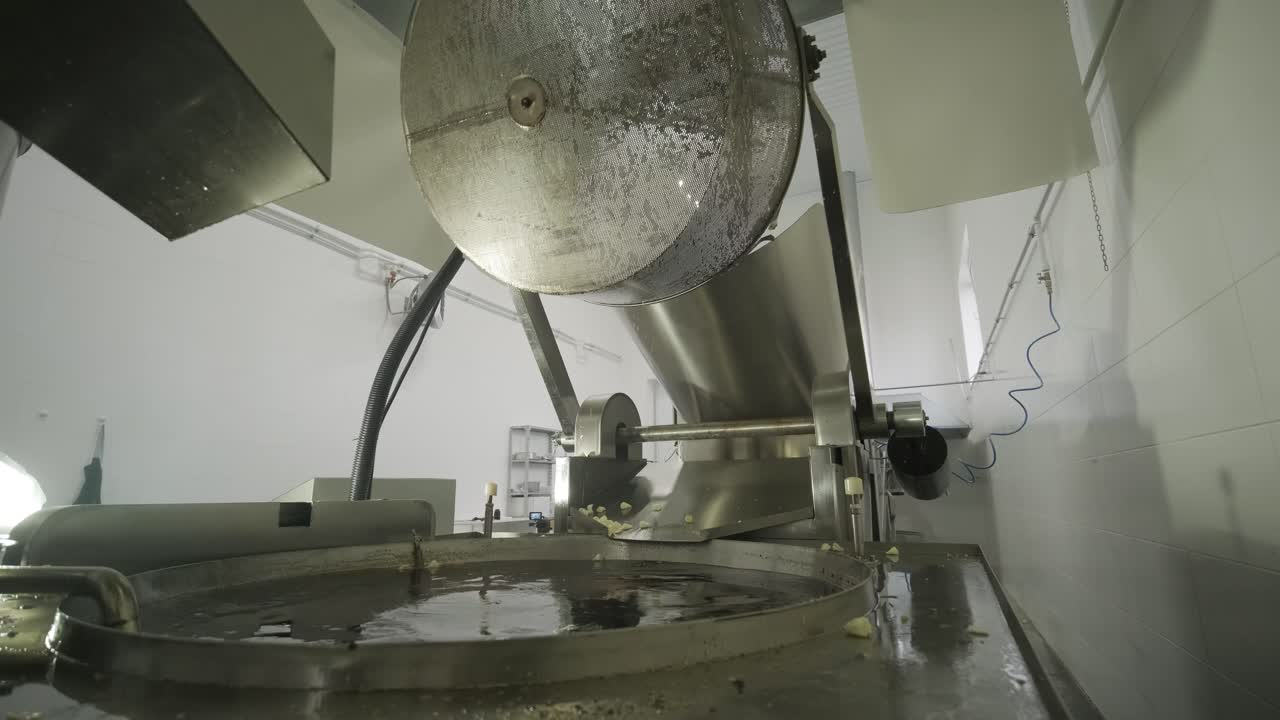 máquina de fritura industrial, las papas fritas se fríen en un cuenco grande con aceite
