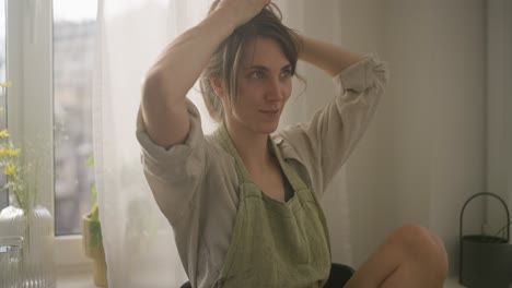 una mujer relajándose junto a la ventana.