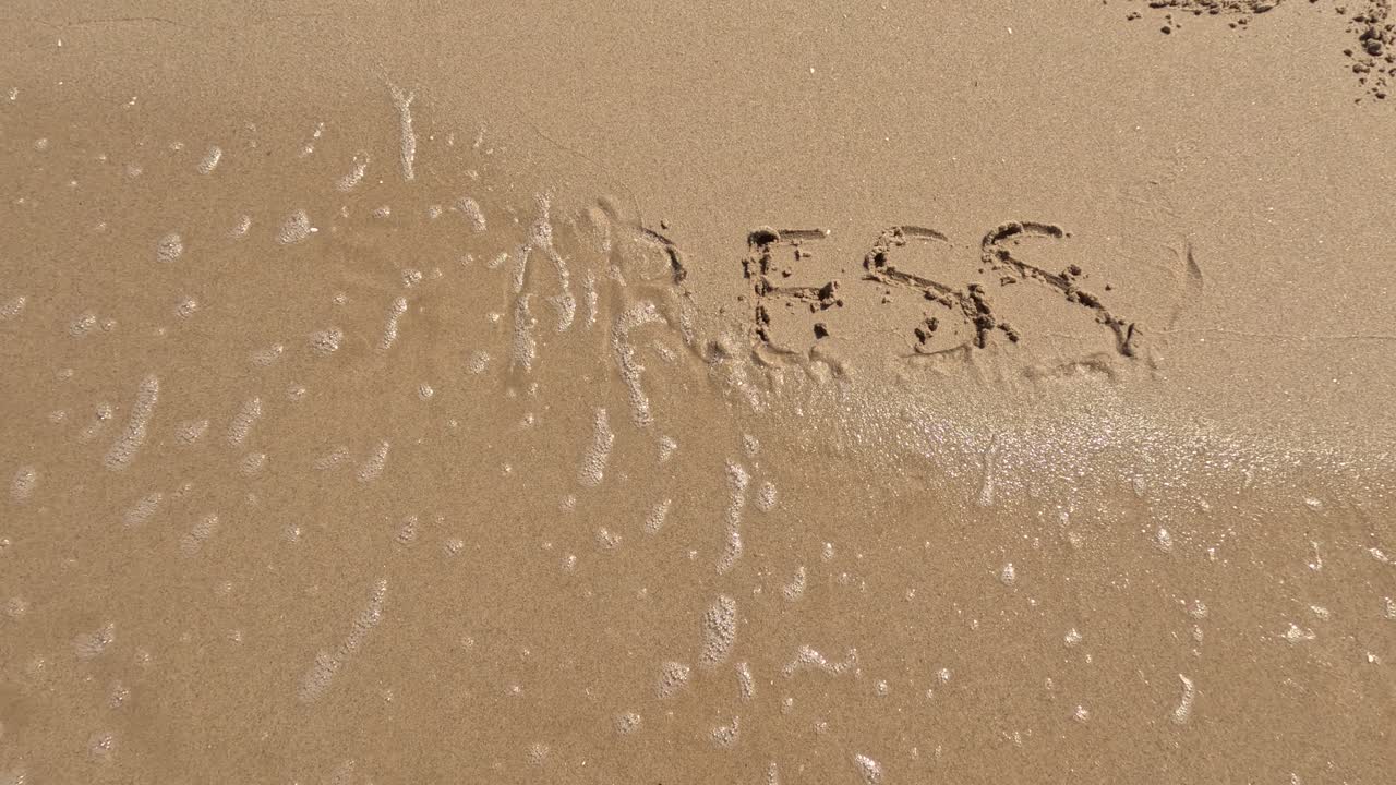 &amp;quot;Stress&amp;quot; word is written on the beach sand and erased with a wave, a concept video of relaxation and stress relief
