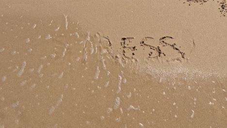 "stress" word is written on the beach sand and erased with a wave, a concept video of relaxation and stress relief