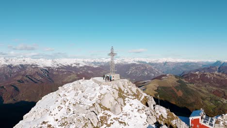 vista aérea de la cruz de punta cermenati en el pico cubierto de nieve en el monte resegone