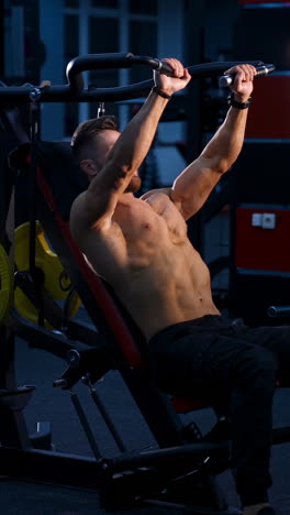fit young man lifting barbells doing workout at a gym. sport, fitness, weightlifting, bodybuilding, training, athlete, workout exercises concept. view from the side. vertical video