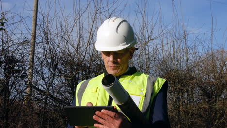 a mature professional architect with a tablet inspecting a construction building site