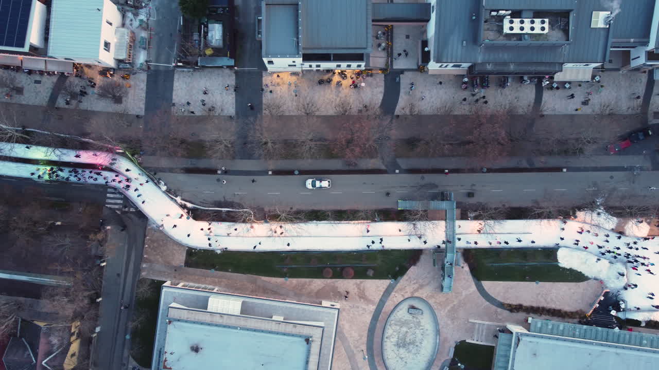 Aerial of skaters looping between buildings on icy paths in Balatonfured winter center