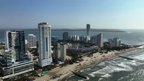 Aerial-view-towards-a-beach-and-hotels-in-sunny-Bocagrande,-Cartagena,-Colombia