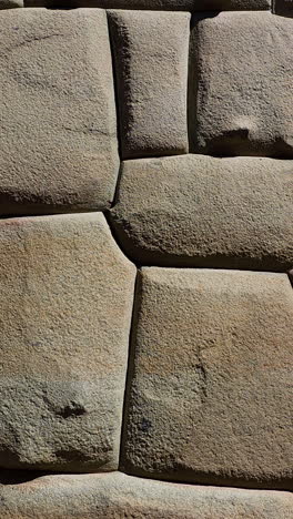 a close-up video showcasing the incredible detail and precision of a historic inca wall in cusco, peru. the masterful stonework and interlocking, mortar-less construction of this ancient civilization