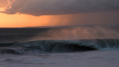 dramatic ocean waves under a sunset sky