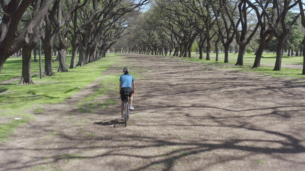 Aerial View of Man Riding a Bike along Park Alley