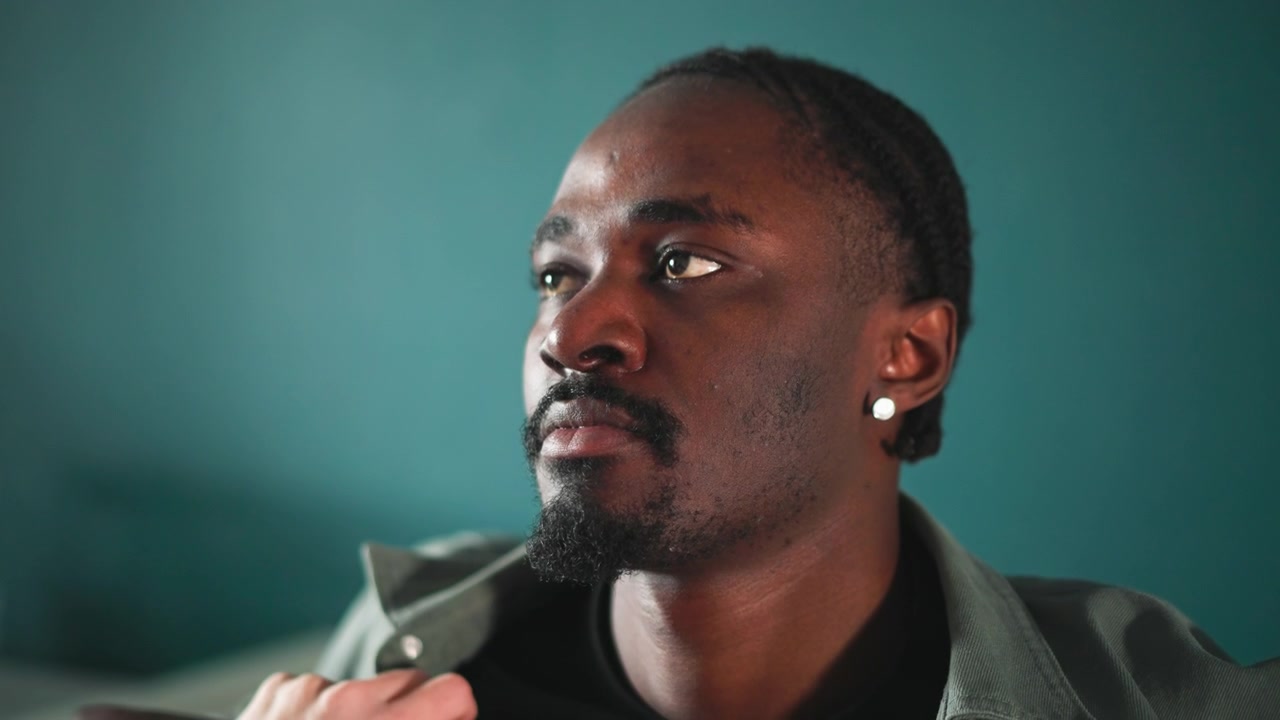 Black patient receiving home assessment by paramedic, nurse checking vitals, doctor conducting teleconsult, family member offering support, medic documenting condition. Closeup portrait in teal