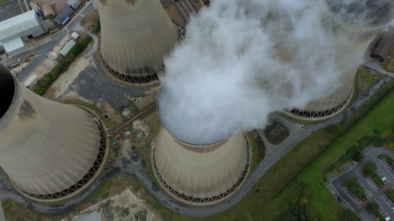 High altitude reveal of coal gas and oil fueled plant with cooling towers and steam plumes near Selby England