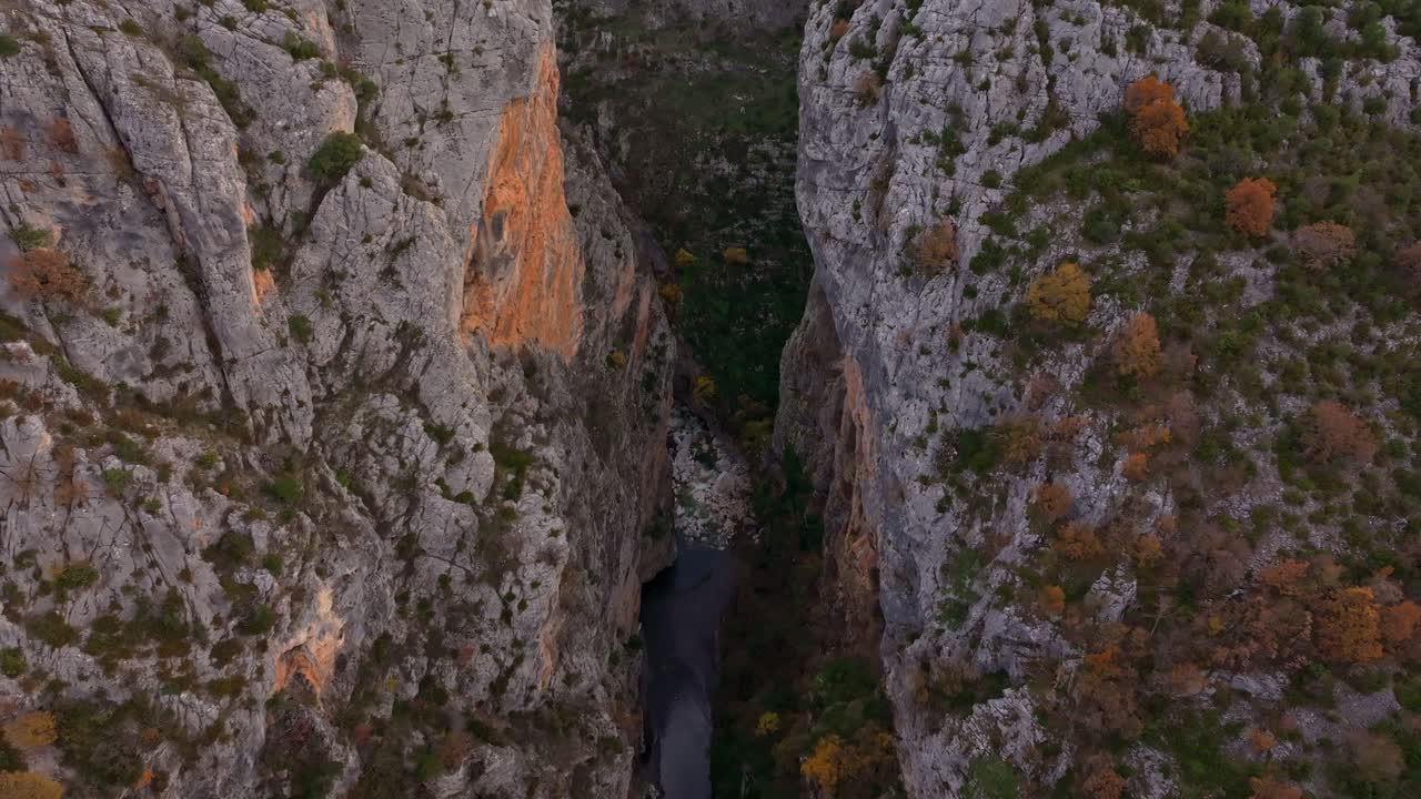 Drohnenaufnahme einer Steinbrücke mit Mann in der Portitsa-Schlucht, Spileo