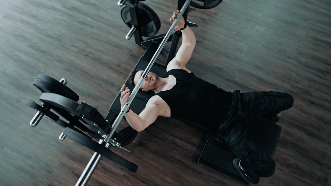 Muscular Man Doing Barbell Exercise. Man working out barbell bench press in the gym