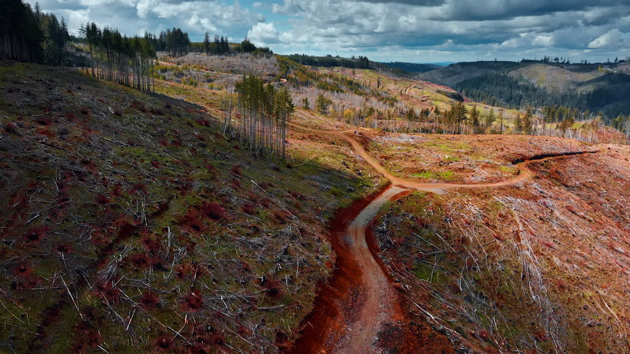Rocky hills covered with leftovers from dry trees. Top view on the mountains crossed by tourists' trails under the sky with dramatic cloudscape.