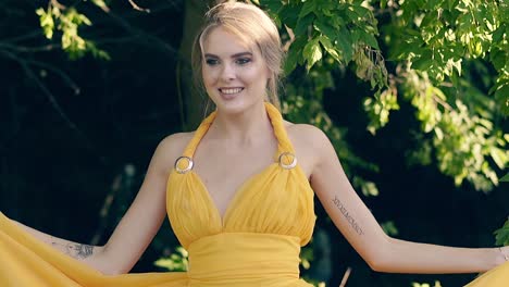 cu slow motion young beautiful girl in a beautiful yellow fluttering dress whirls