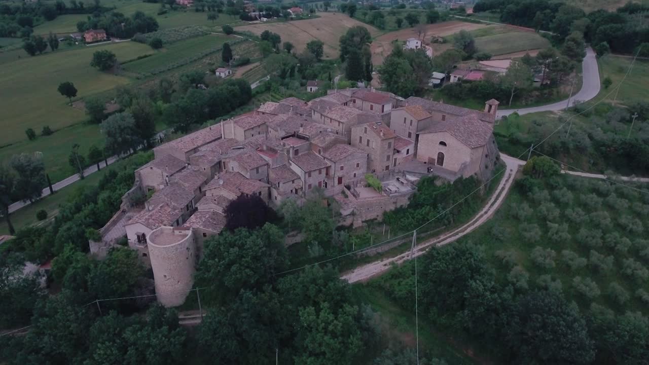 Ripresa aerea con drone: movimento in picchiata e inclinazione, centrato su un borgo medievale italiano in Umbria, Italia.