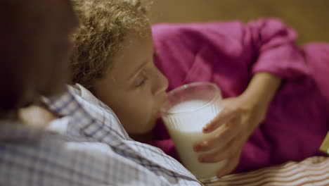 closeup of girl listening to goodnight stories and sipping milk