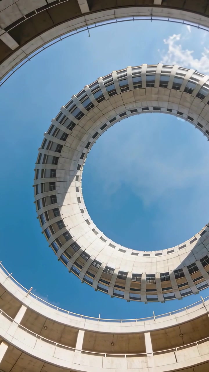 Video verticale: Telecamera inclinata che mostra un anello di cemento che si allinea in alto su una rampa, rivelando il cielo blu.