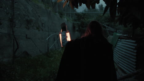 lonely enigmatic woman explores a scary place in the haunted forest at night