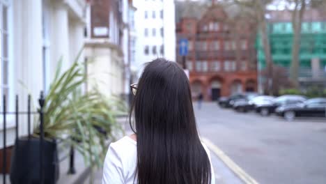 Mujer-Joven-Gira,-Cabello-Voltea,-Soho,-Londres,-Cámara-Lenta-De-Plano-Medio