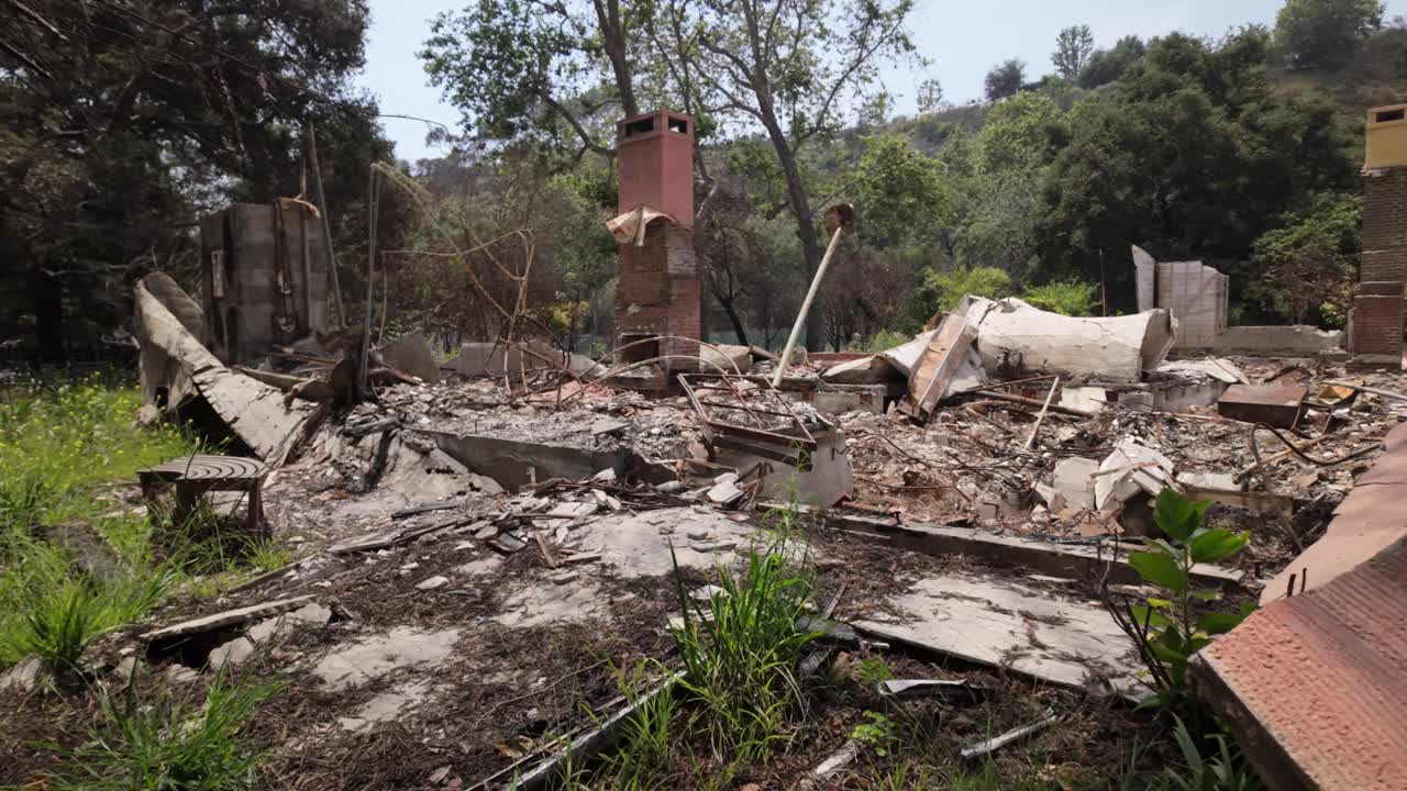 Gimbal wide panning shot of a burned home in the aftermath of the Palisades Fire in Southern California. 4K