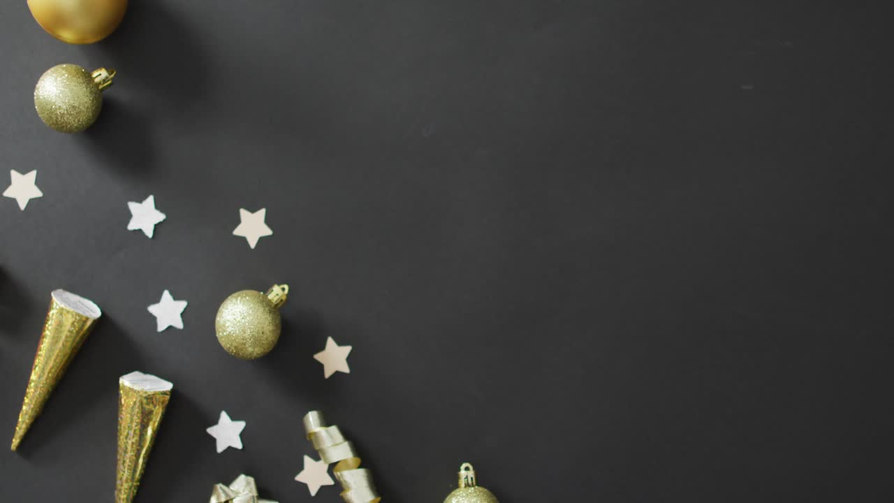 Baubles and stars on black background at new year's eve