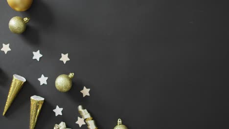 Baubles-and-stars-on-black-background-at-new-year's-eve