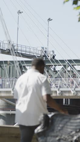 Vertical-Video-Of-Commuters-Crossing-Hungerford-Charing-Cross-Bridge-In-London