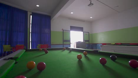 close up forward shot of indoor billiard room with spread balls during daytime