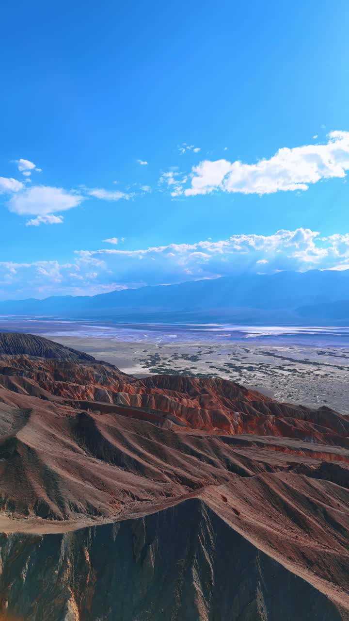 Wonderful ridged mountains with no vegetation. Sun beams go through the clouds lighting the Death Valley National Park, California, USA. Vertical video