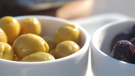 green and black olives in small bowls