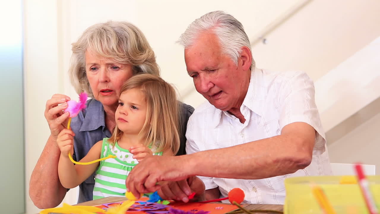 Nonni che fanno lavoretti con la loro nipotina