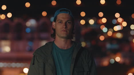 portrait attractive young caucasian man smiling on rooftop at night enjoying weekend nightlife in city