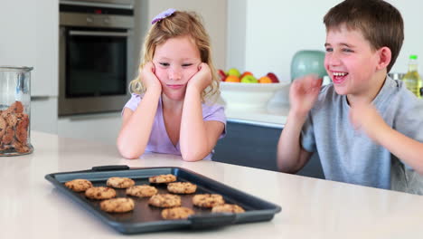 siblings waiting for hot cookies to cool down