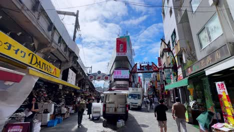 bustling shopping street with people walking under a bright blue sky in a lively urban setting