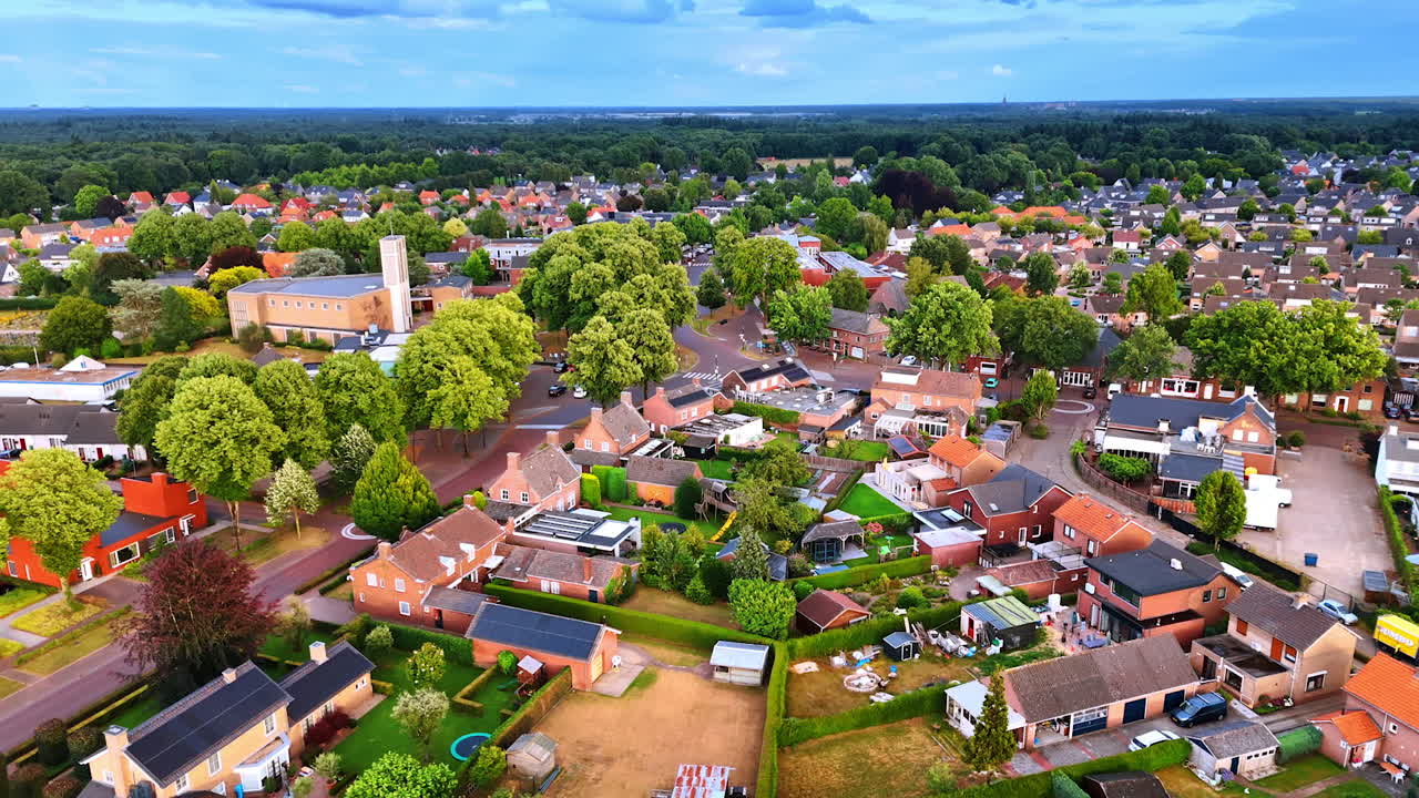 Aerial view of a calm neighborhood. Aerial view reveals a peaceful neighborhood with trees, homes, and open spaces in soft late afternoon light
