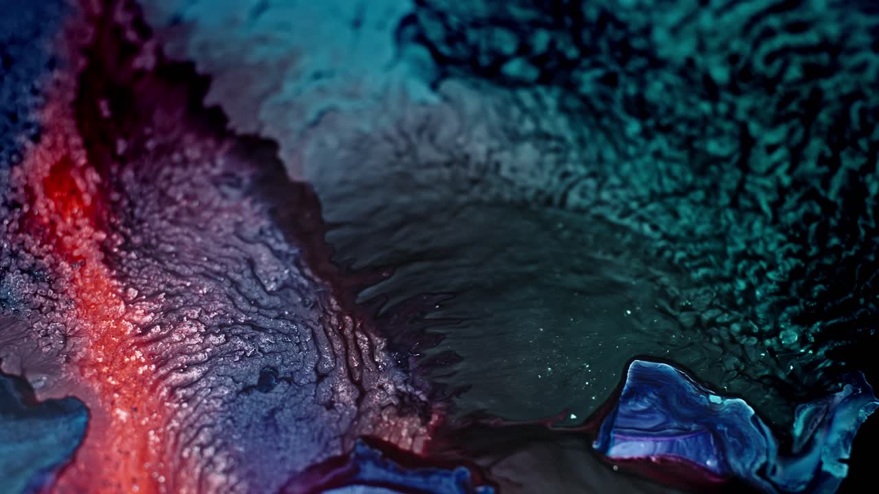 Colori vivaci dell'inchiostro che si fondono nell'acqua, creando una texture artistica astratta e fluida.