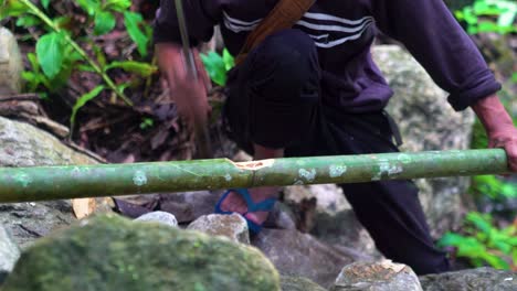 Close-up-shot-of-a-Khasi-Tribe-member-using-a-knife-to-carve-a-ficus-elastica-branch